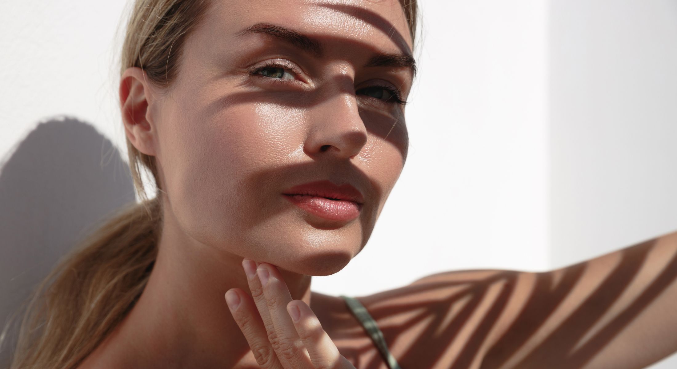 Woman's face partially obscured by shadow patterns.